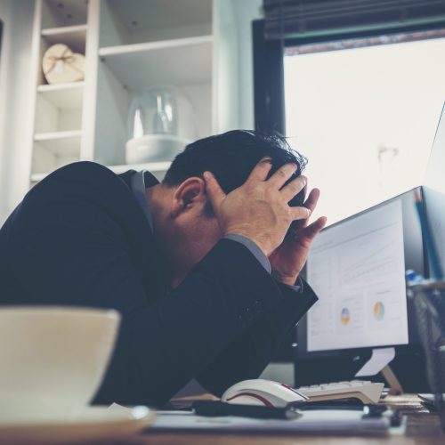 Businessmen are sitting at the working space and he needs medicine after feeling sick and tired